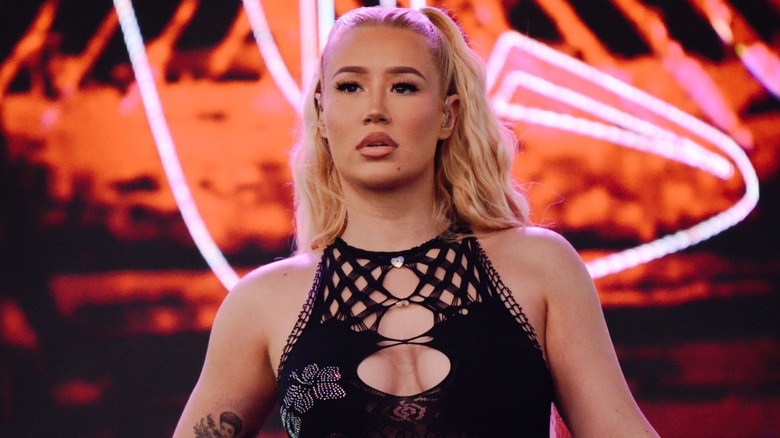 Wearing a revealing meshed black number that exposes her bosom, Iggy Azalea looks at a crowd during a performance.