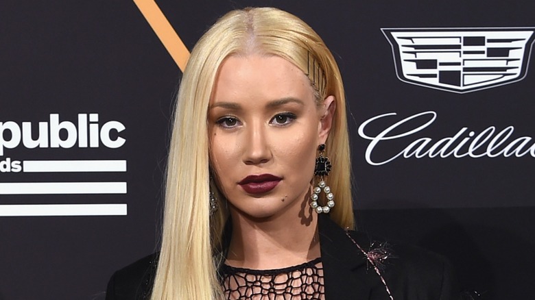 Dressed in a black meshed number and sporting burgundy lipstick, Iggy Azalea looks into the camera.