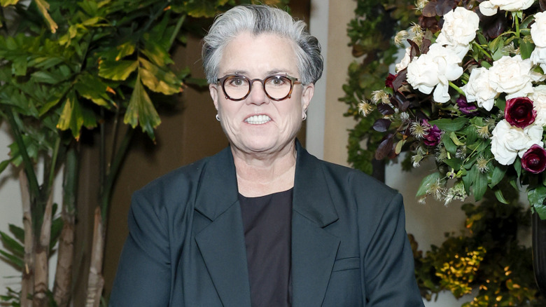 Rosie O'Donnell in front of flowers