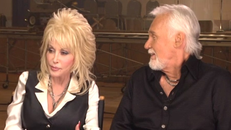 Kenny Rogers looks at Dolly Parton as she speaks.