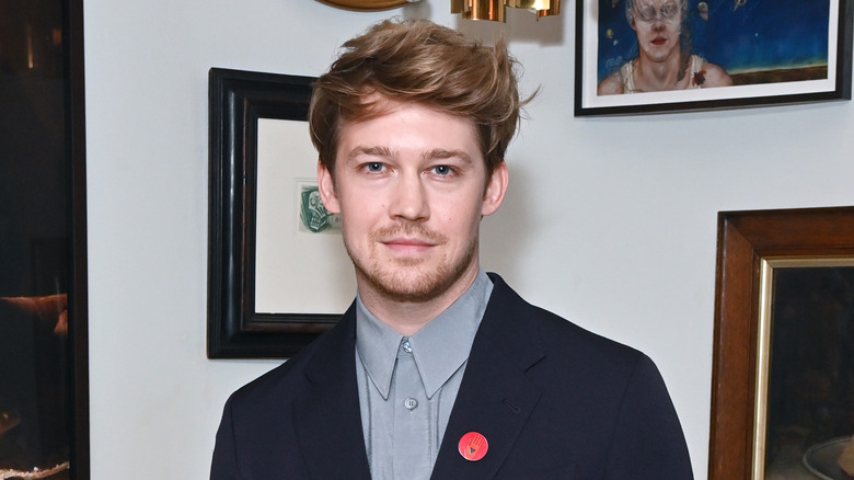 Joe Alwyn posing with art