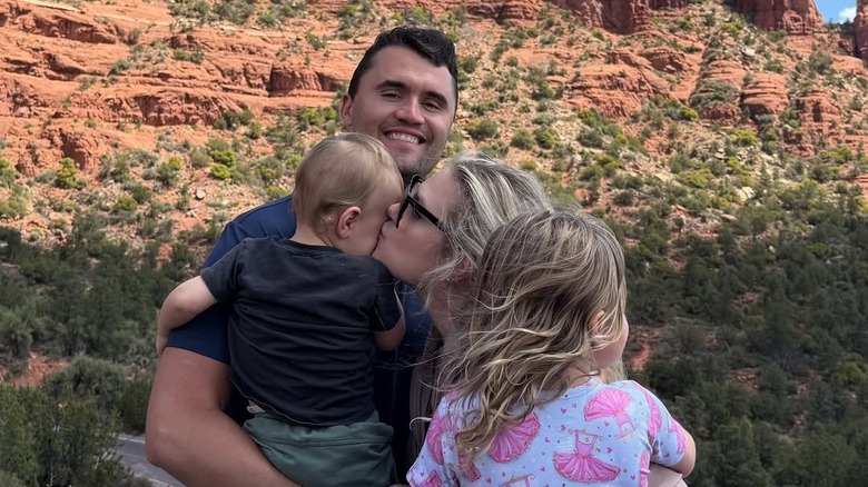 Charlie and Erika Kirk posing for camera with their two children
