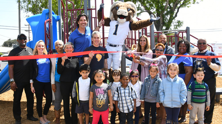 Carter Oosterhouse posing and smiling with a group of adults and children at Carter's Kids Playground Build and Ribbon-Cutting Ceremony