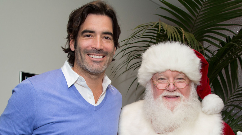 Carter Oosterhouse smiling with Santa Claus at HGTV Holiday House Kick-Off at Santa Monica Place