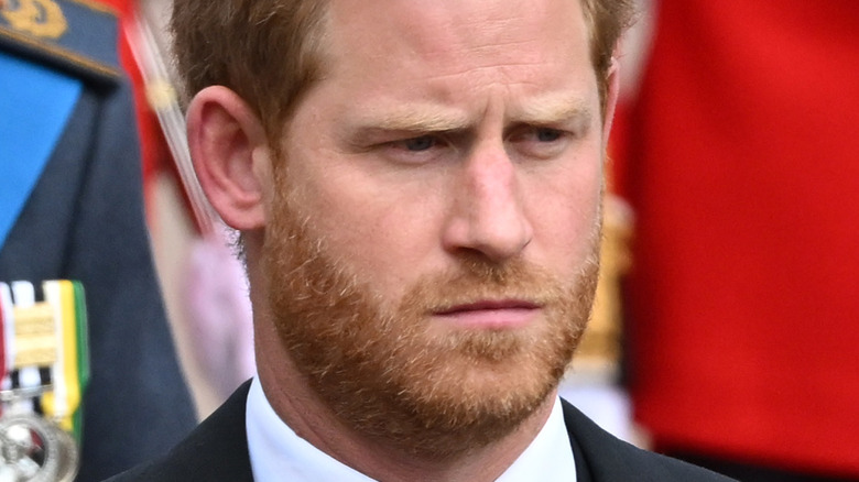 Prince Harry frowning in black suit