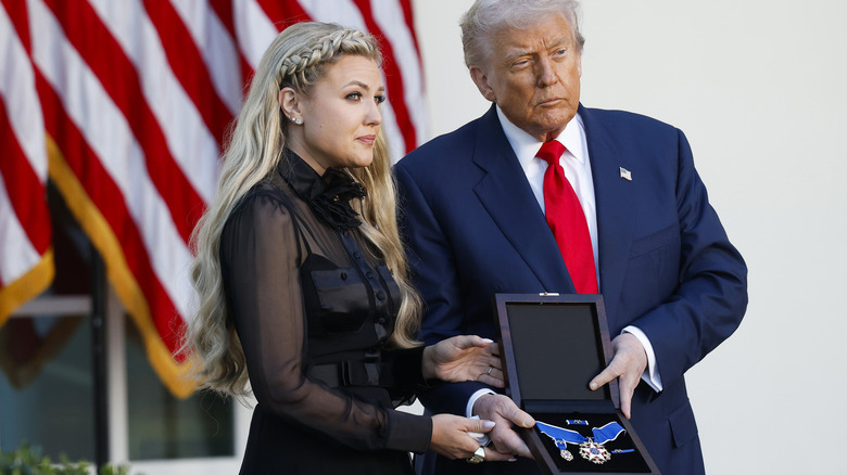 Erika Kirk and Donald Trump holding the Presidential Medal of Freedom