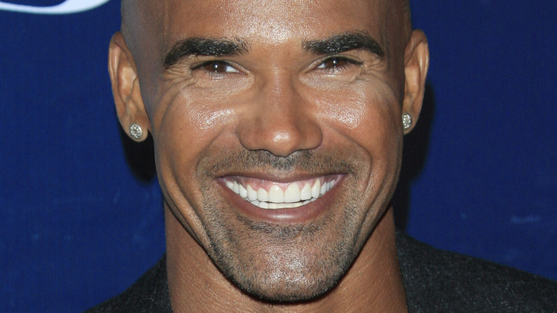 Shemar Moore smiles against blue background
