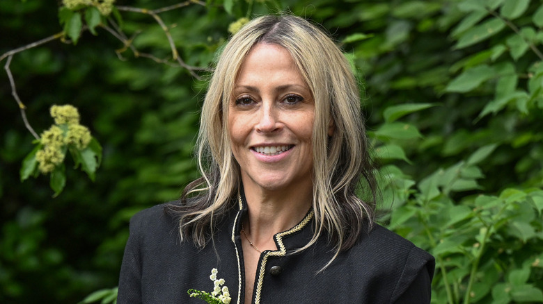 Nicole Appleton smiles in front of trees