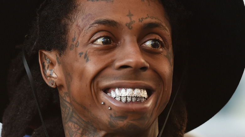 Lil Wayne smiling and wearing a hat