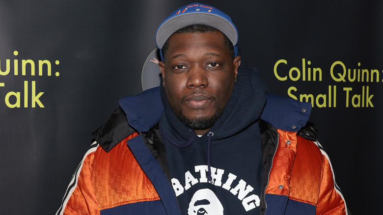 Michael Che orange coat