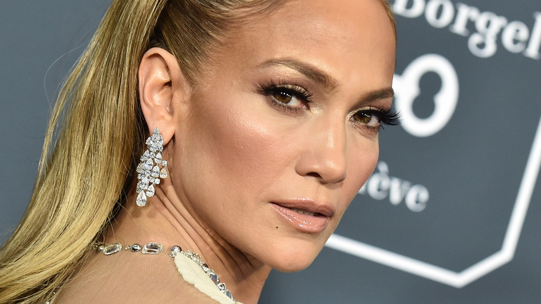Jennifer Lopez looking over her shoulder, in diamond earrings