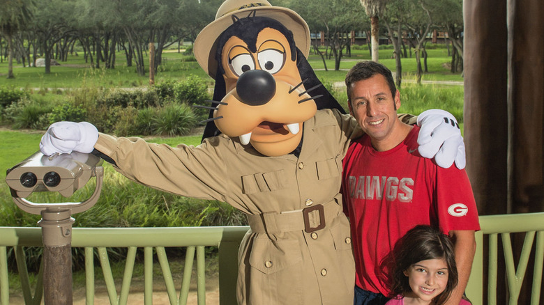 Adam Sandler poses with Goofy