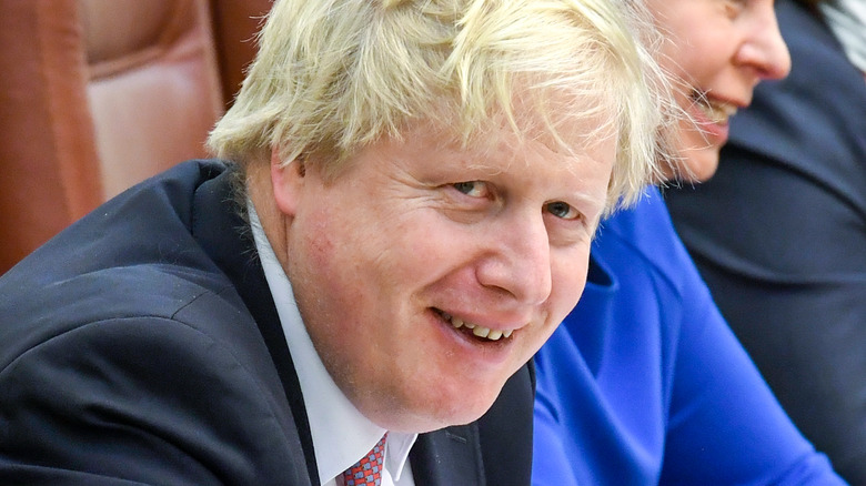 Boris Johnson seated and laughing