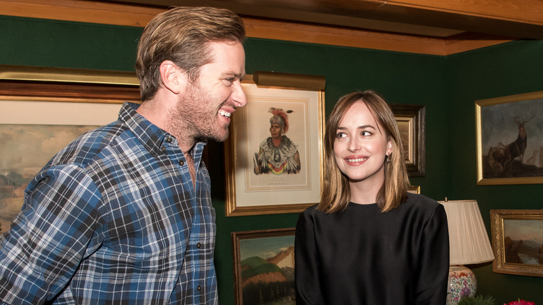 Dakota Johnson looking at Armie Hammer