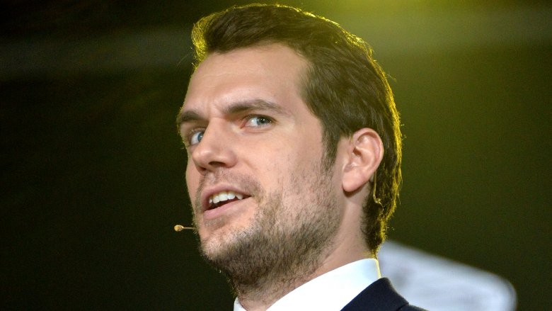 Henry Cavill wearing an earpiece and looking like a creep
