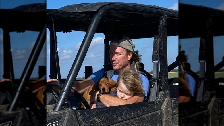 Chip Gaines driving with puppy and son in his lap