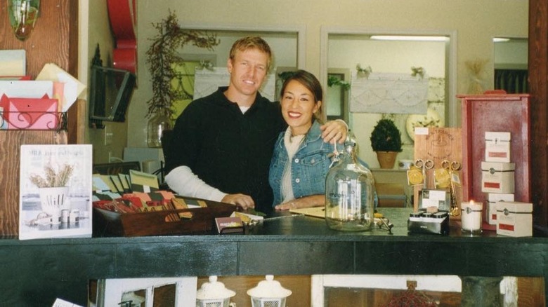 Chip and Joanna Gaines posing behind Magnolia shop counter