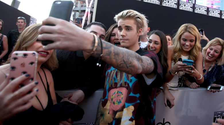 Justin Bieber posing with fans 