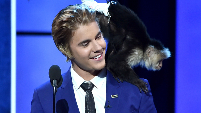 Justin Bieber posing with monkey 
