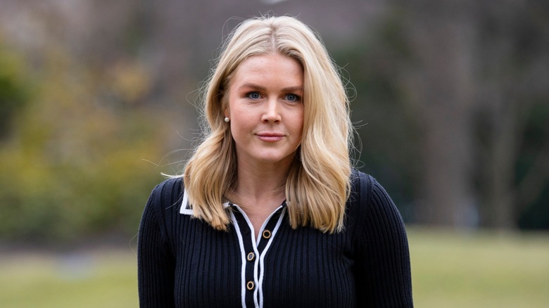Dressed in black, Karoline Leavitt walks on the White House lawn.