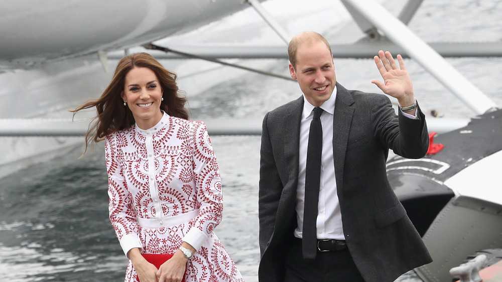 Kate Middleton smiling next to Prince William waving
