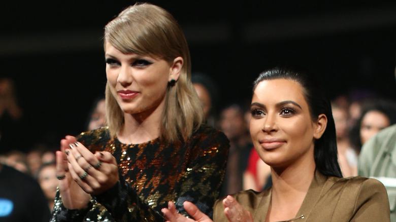Kim Kardashian applauding with Taylor Swift