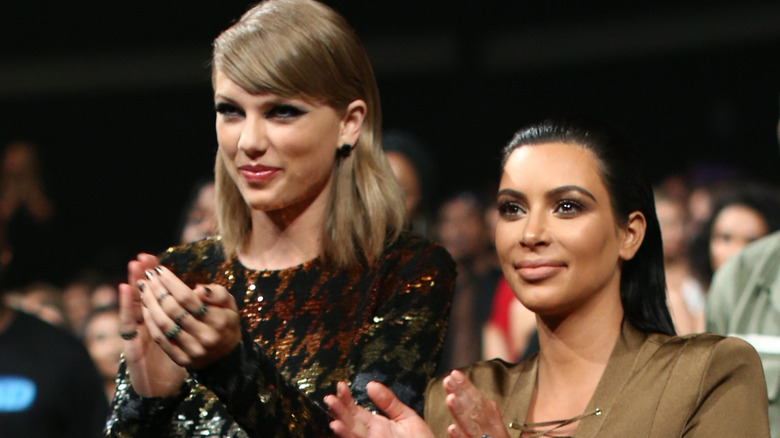 Kim Kardashian applauding with Taylor Swift