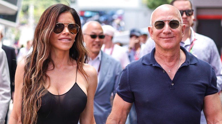 Jeff Bezos and Lauren Sanchez are all smiles while holding hands.