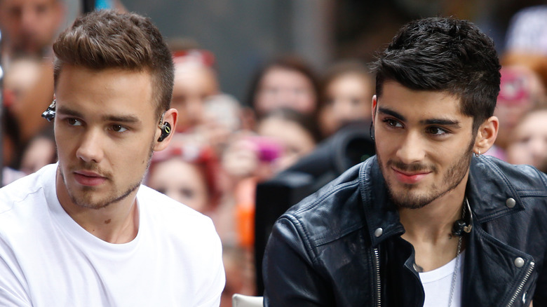 Liam Payne and Zayn Malik, seated, looking away
