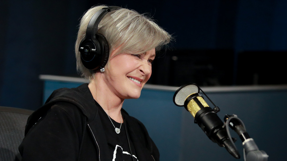 Sharon Osbourne smiling and speaking into a radio mic 