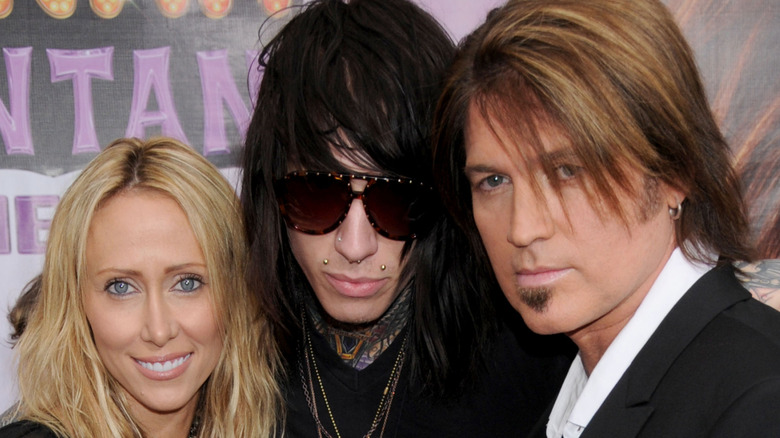Tish, Trace, and Billy Cyrus posing on red carpet