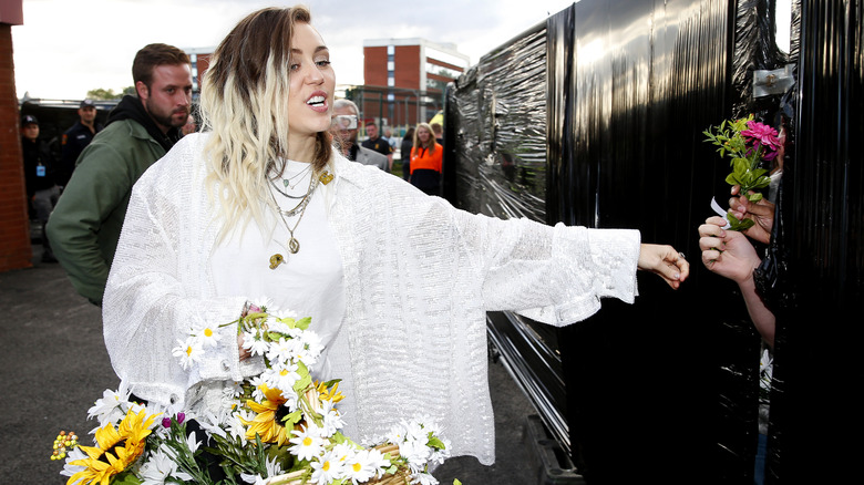 Miley Cyrus wearing white outfit at Old Trafford