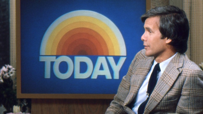Tom Brokaw speaking in front of Today show logo