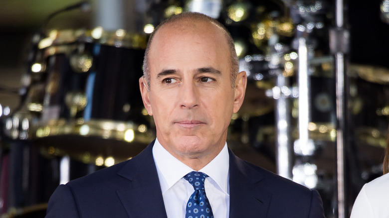 Matt Lauer posing in front of a drum kit