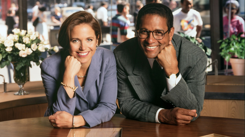 Katie Couric and Bryant Gumbel posing behind a desk
