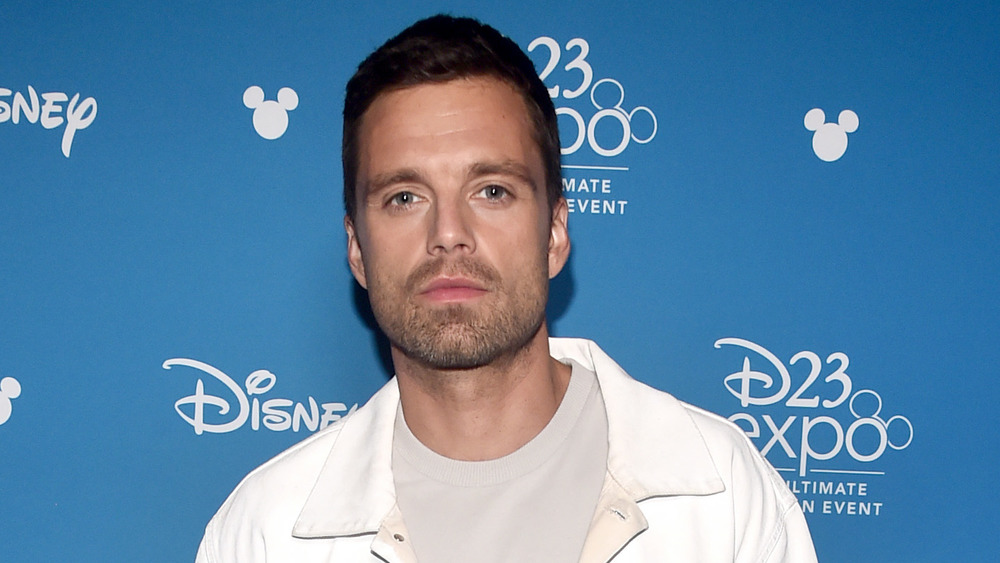 Sebastian Stan looking stoic in a white collared shirt 
