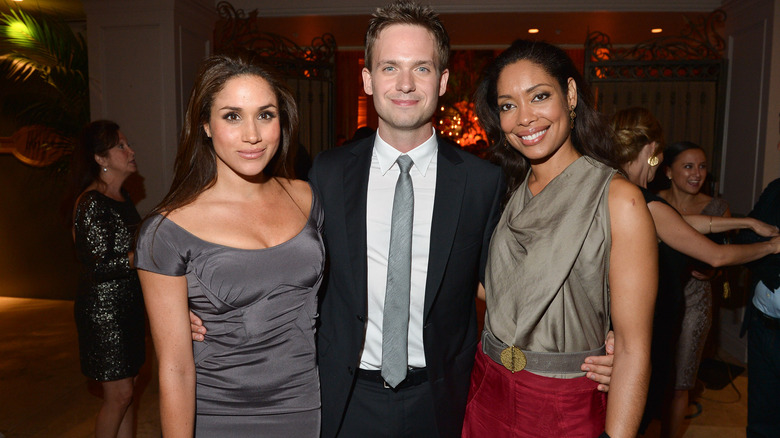 Meghan Markle, Patrick J. Adams, and Gina Torres posing