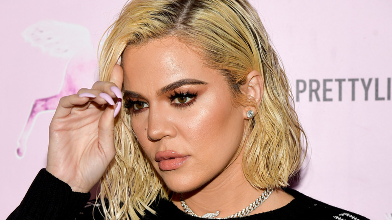 Khloé Kardashian touching forehead