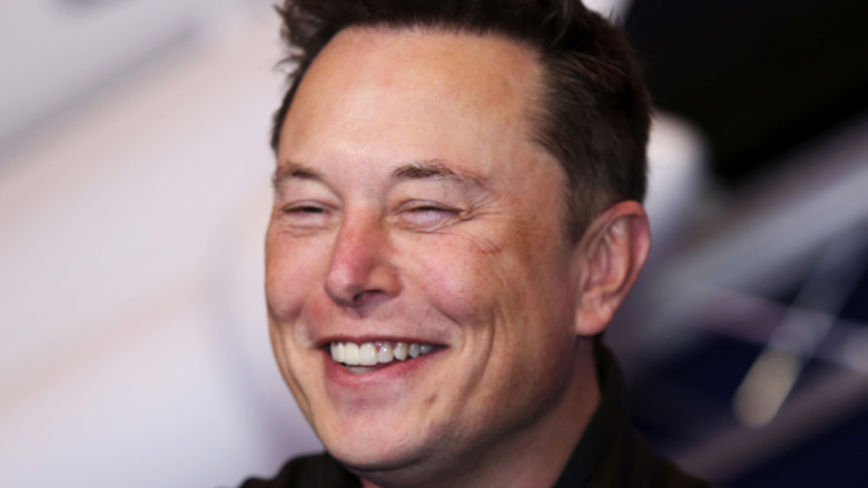 Elon Musk smiles at an event