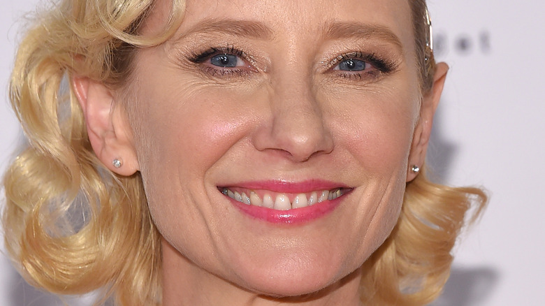 Anne Heche smiles in pink lipstick