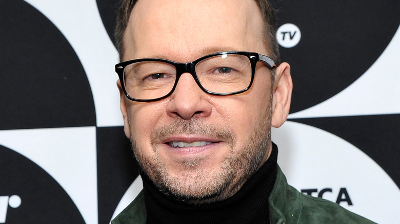 Donnie Wahlberg poses in black-framed glasses.