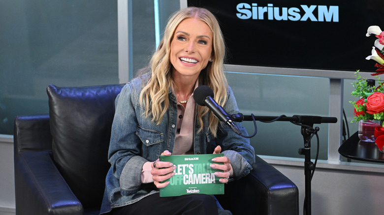 Kelly Ripa chatting animatedly in a SiriusXM interview.