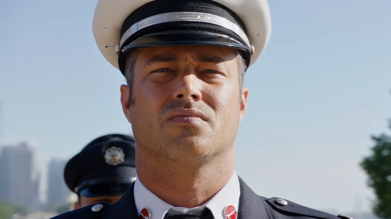 Taylor Kinney wears a fire department cap