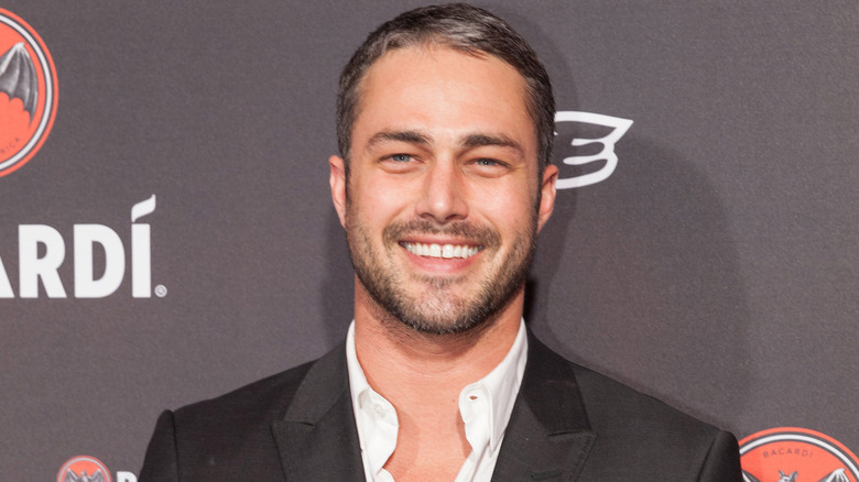 Taylor Kinney wears unbuttoned white shirt