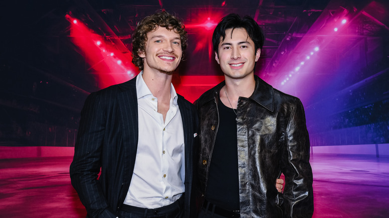 Connor Storrie in a black pinstriped jacket and Hudson Williams in a black leather jacket