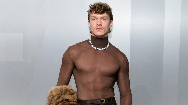 Connor Storrie wearing a sheer black turtleneck and silver chain