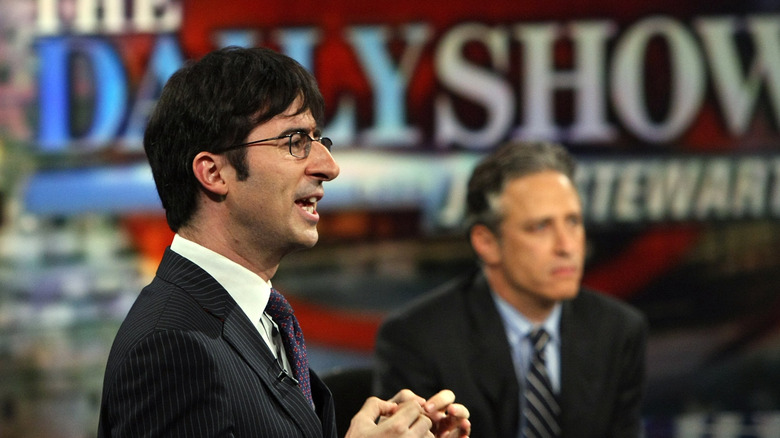 John Oliver and Jon Stewart standing on stage next to each other
