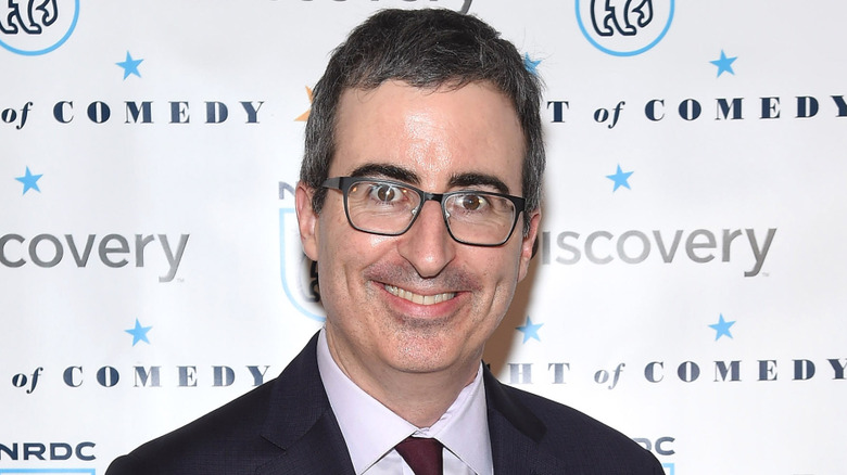 John Oliver smiling while standing on the red carpet