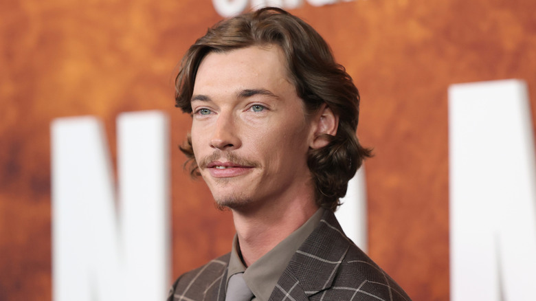 Jacob Lofland in front of an orange background at Landman premiere