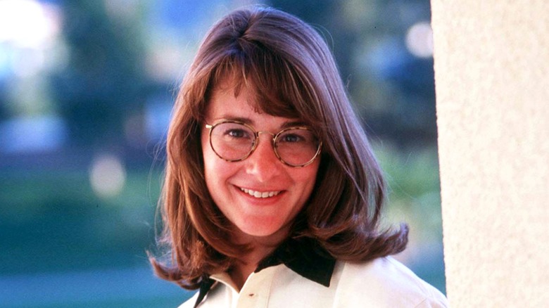 Melinda Gates, with bangs and wearing geeky glasses, displays a gentle smile.
